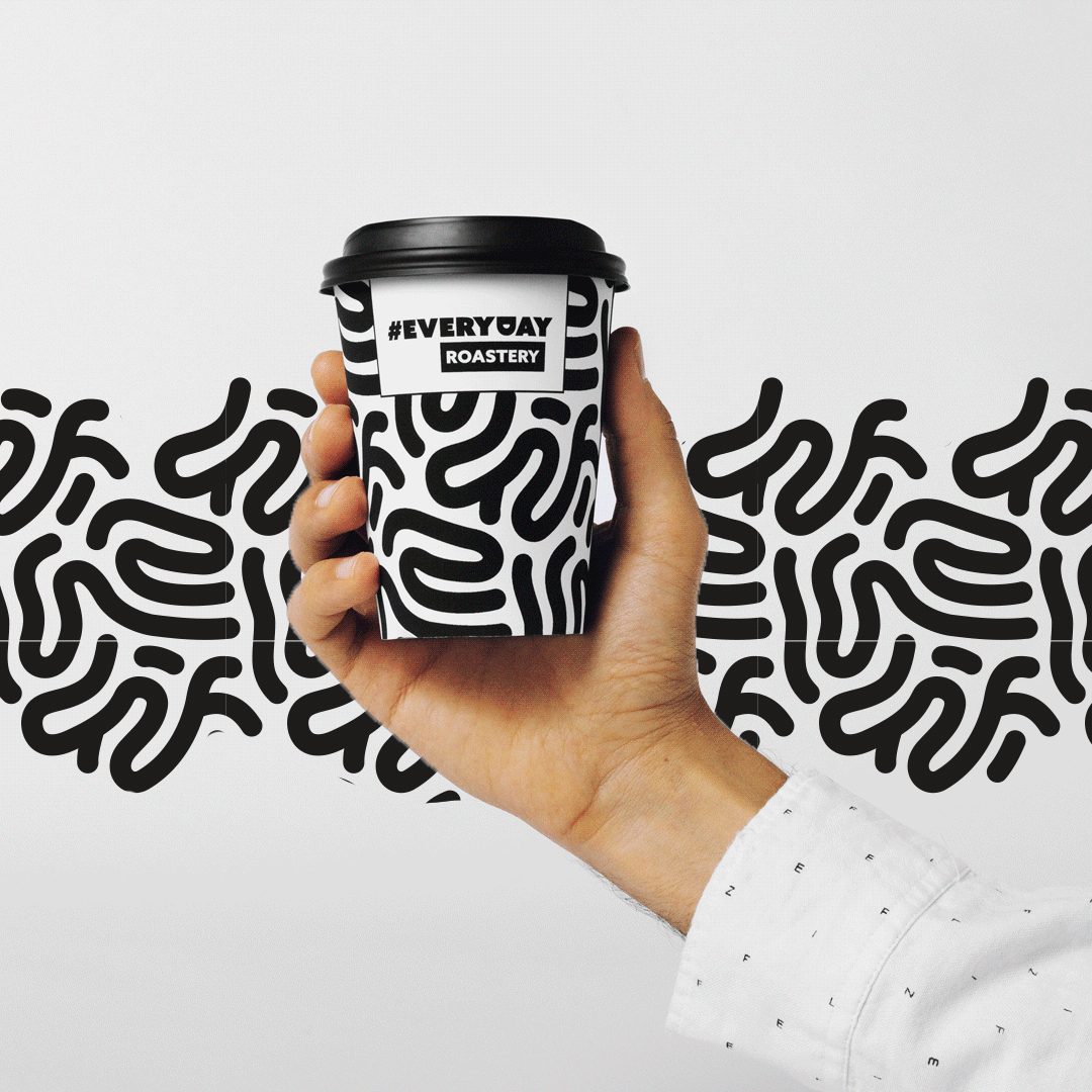Hand holding an Everyday Roastery cup over an animated black and white pattern
