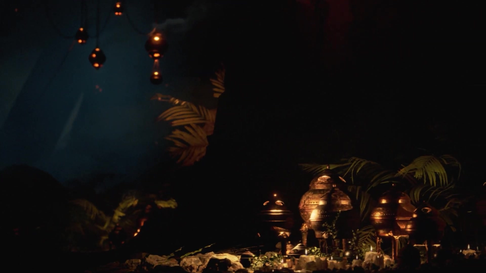Metal vessels and foliage beneath hanging lamps in a shadowy cavern